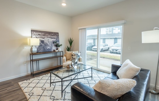 a living room with a black leather couch and a glass coffee table at Technology Park Apartments, Rochester, 55901