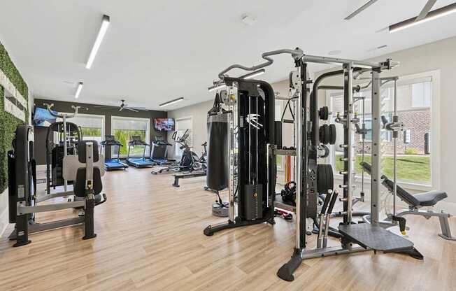 A gym with a variety of equipment including a squat rack, leg press, and a bench press.