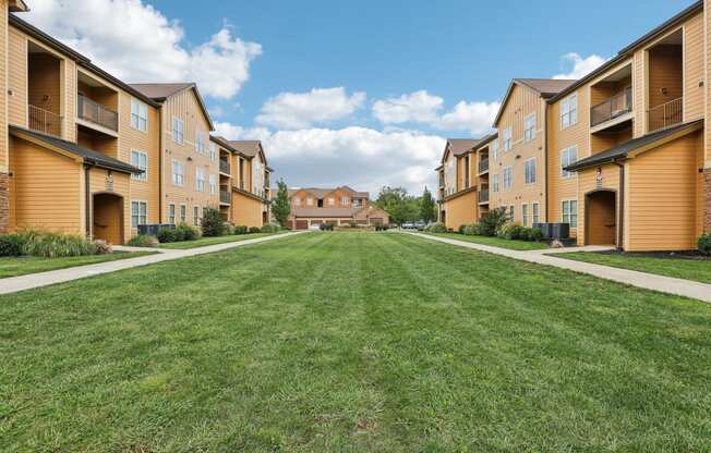 a green lawn in front of a row of houses