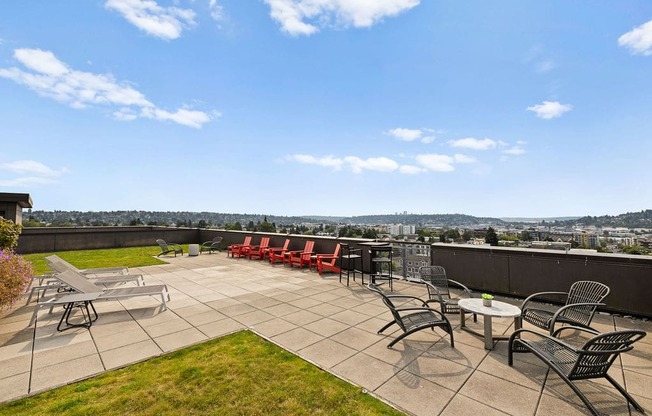 A patio with a table and chairs overlooking a city.