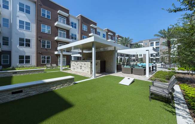 a courtyard with a lawn and a pavilion with a pool