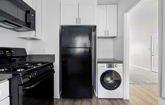 a kitchen with a refrigerator freezer and a washer and dryer