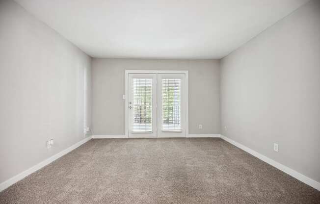 an empty living room with white walls and a door to a balcony at Shellbrook, Raleigh, NC, 27609