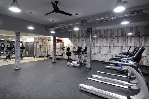 a gym with treadmills and weights on the floor and a ceiling fan at Willowest in Collier Hills, Atlanta, GA