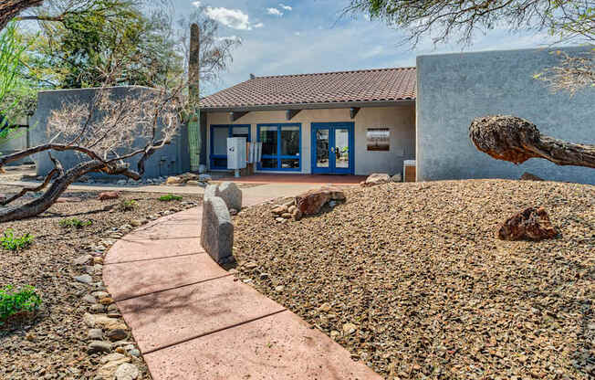 a house with a pathway and trees in front of it
