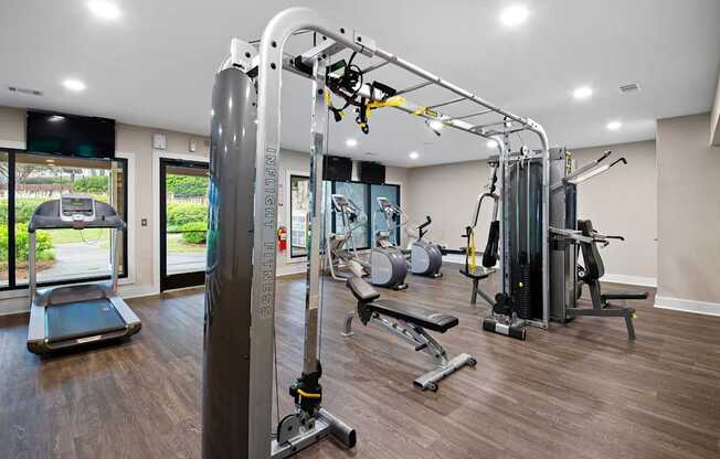 A gym with a treadmill, weights, and a pull up bar.