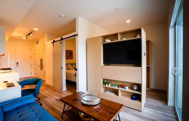 a living room with a blue couch and a television