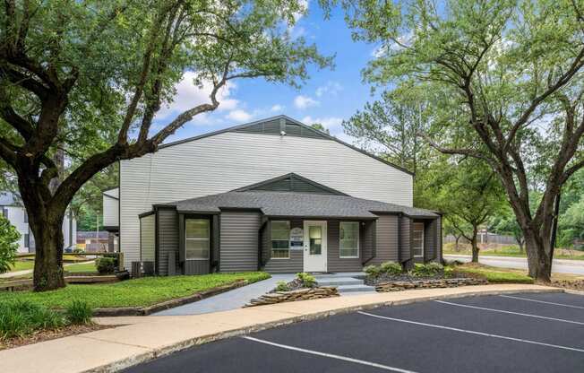 a white and gray building with trees in the background