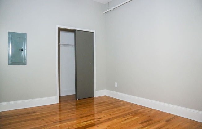 an empty room with wood floors and a closet