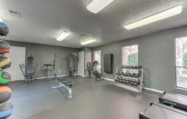 A well-equipped gym with a variety of exercise machines and weights at Copper Hill Apartments, Bedford, Texas