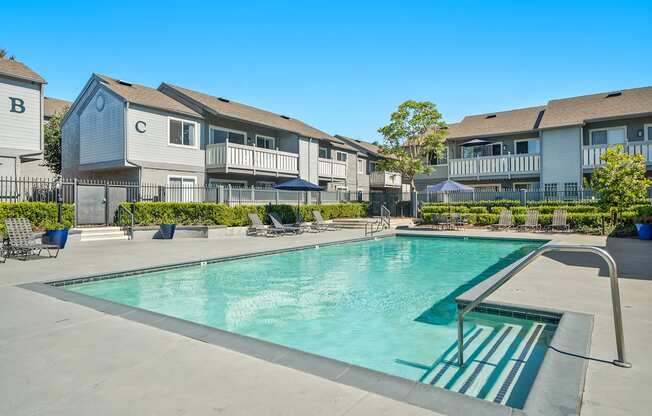 a swimming pool with apartment buildings in the background