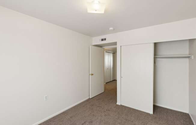 a bedroom with white walls and white closet doors