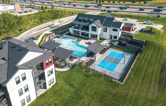 a mansion with a pool and a house with a tennis court