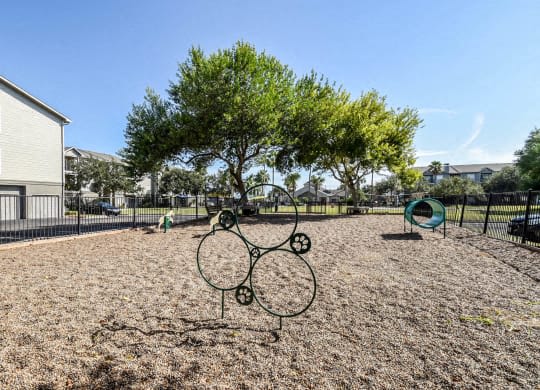 a playground with two tennis rackets in front of a tree