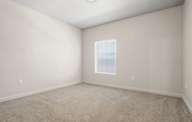 an empty room with carpet and a window