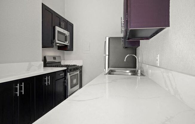 Apartments in Sherman Oaks for Rent- Brody Terrace- Kitchen with Quartz Countertops, Stainless-Steel Appliances, and Dark Wood Cabinets