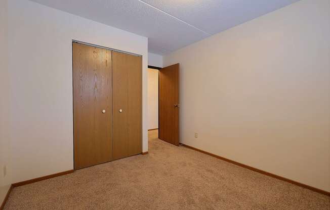 a bedroom with a closet and a door to a hallway at France, Fargo, 58103