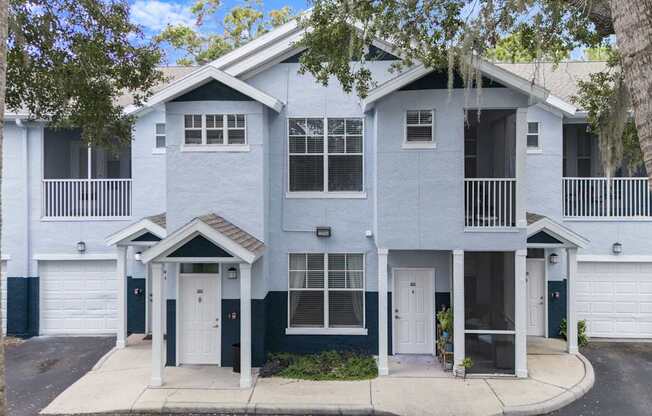 A two-story house with a white garage door and a black door.