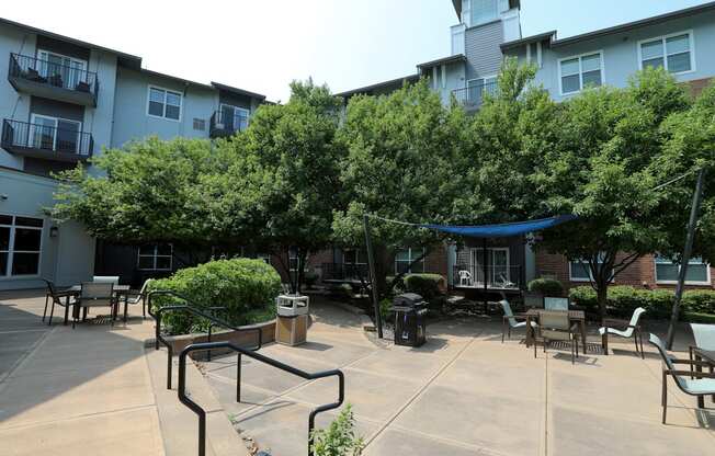 a courtyard with trees and awnings in front of a building