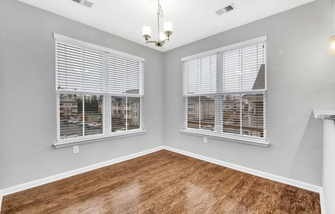 a living room with windows and a wooden floor