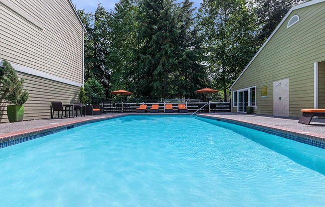 a large swimming pool with umbrellas and chairs around it