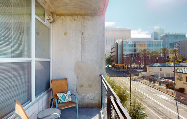 a balcony with a chair and a view of the city