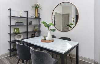 a dining room with a table and chairs and a mirror at The Tribute, Raleigh, NC