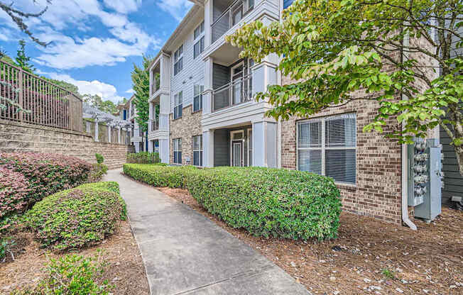 A residential building with a well-maintained lawn and a sidewalk.