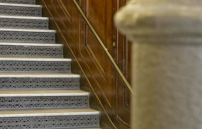 a set of stairs with a metal railing and a wood wall