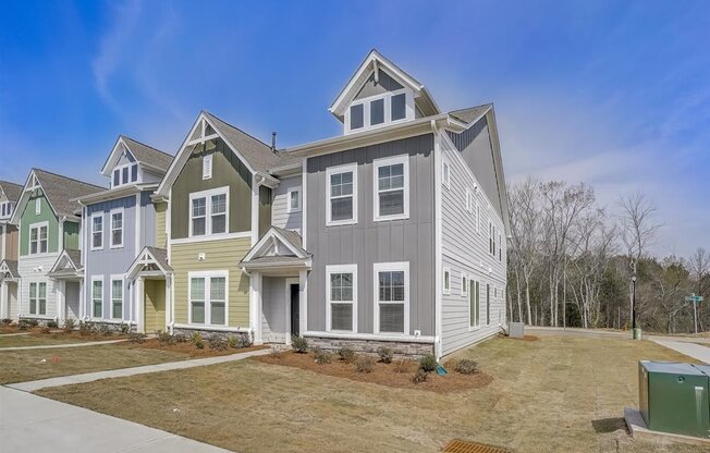 a row of houses in a neighborhood with a blue sky in the background