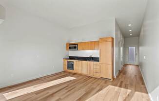 A kitchen with wooden floors and cabinets.