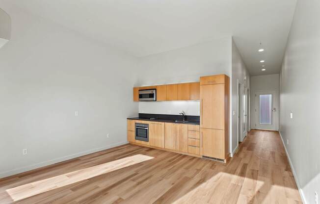 A kitchen with wooden floors and cabinets.