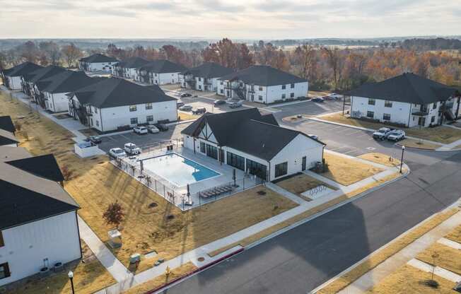 an aerial view of a neighborhood of houses with a swimming pool