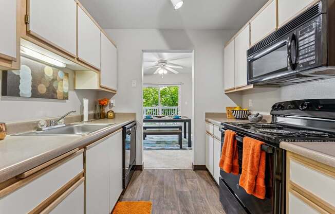 A kitchen with white cabinets and a black stove top oven.