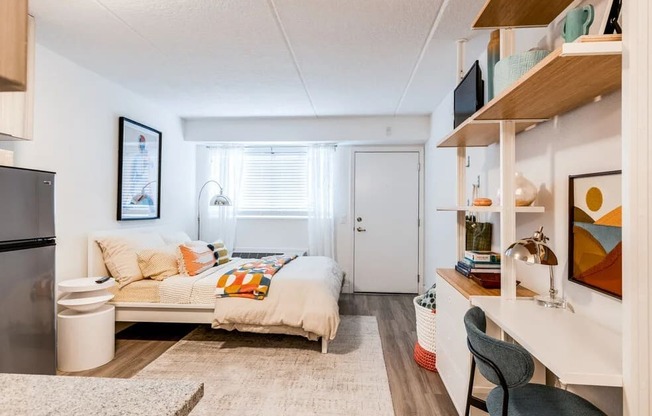 a bedroom with a bed and a refrigerator and a window at The Teale Navy Yard, North Charleston, South Carolina