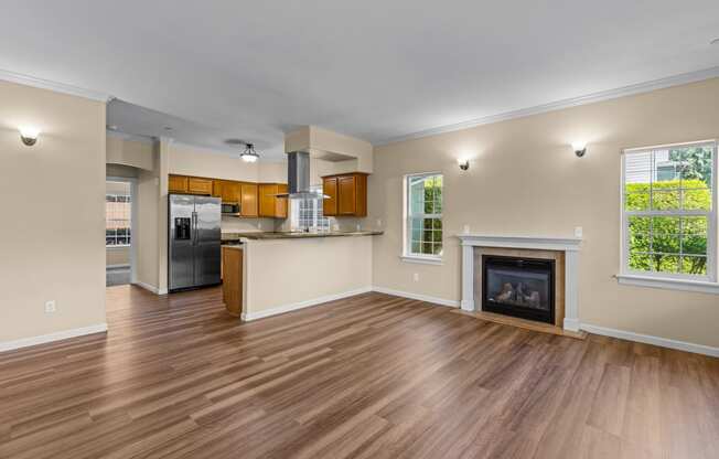 Little Tuscany Apartments & Townhomes - Living Room with Fireplace, Breakfast Bar, Kitchen with Stainless Steel Appliances, Wood Plan Vinyl Flooring, White Woodwork