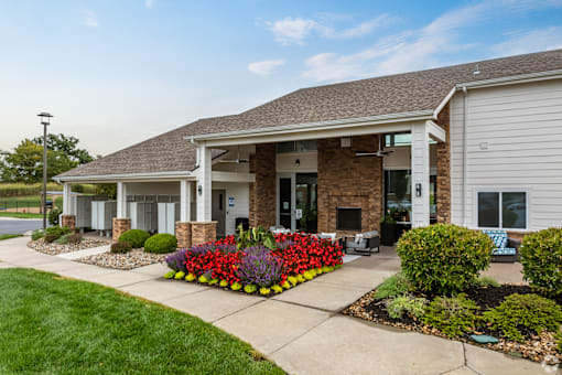 the view of the front of a house with a sidewalk and flower garden