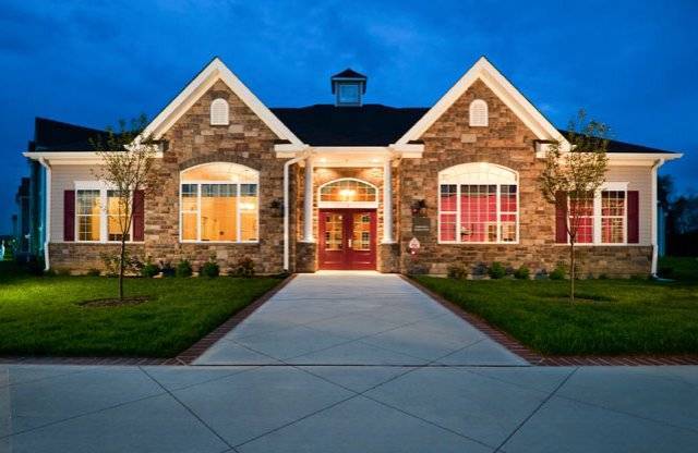 A house with a stone facade and a red door is shown.