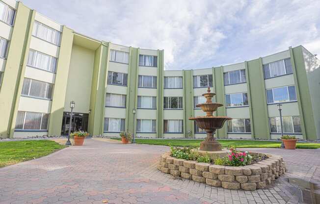 a courtyard with a fountain in front of an apartment building