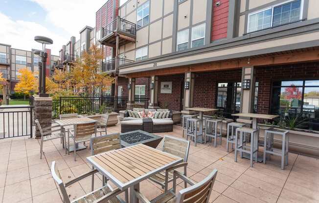 A patio with a table and chairs is surrounded by a fence and trees.