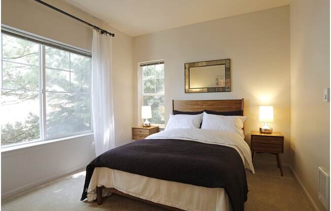A bedroom with a large bed and a window with curtains at Wilsonville Summit Apartments, Wilsonville , Oregon