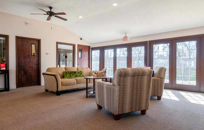 a living room with a couch and chairs and a ceiling fan