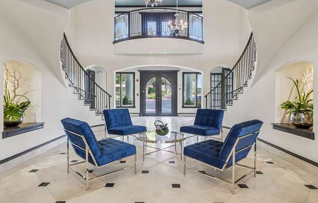 A living room with a spiral staircase and blue chairs.