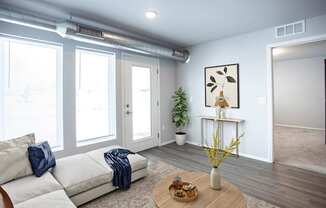 A living room with a white couch and a wooden coffee table.