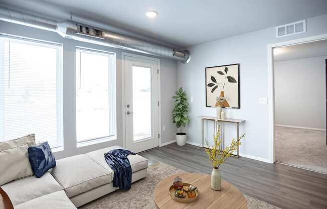 A living room with a white couch and a wooden coffee table.
