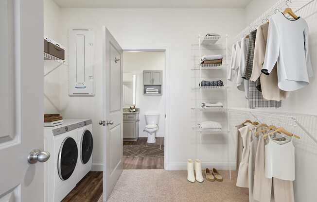 a small laundry room with a washer and dryer in it and a closet