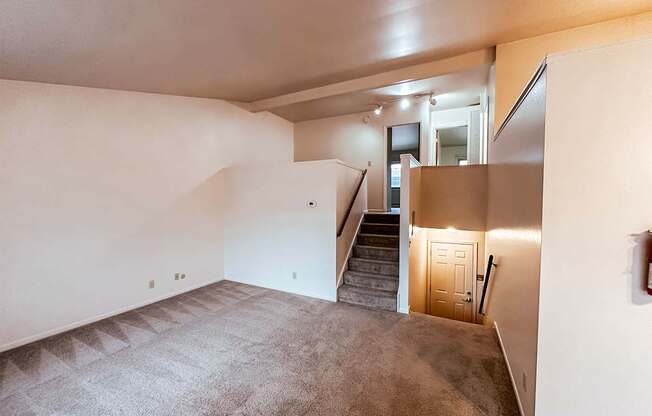 A room with a staircase leading to another room.