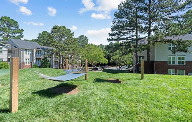 a yard with hammocks and houses in the background