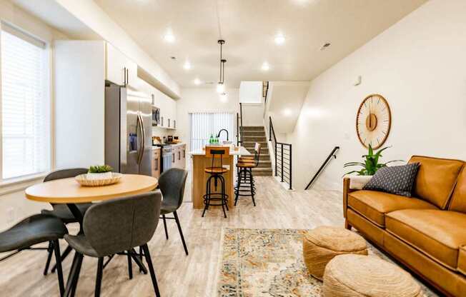 a living room with a table and chairs and a kitchen