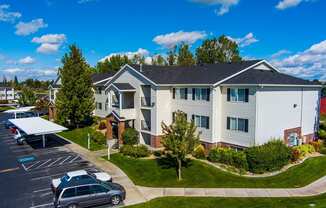 Eagles Landing apartment building with cars parked in reserved resident parking at Eagles Landing Apartments, Ammon, ID, 83406